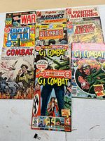 Eight war comics laid out: Charlton War, two Fightin’ Marines, Fightin’ Army, Dell Army War Stories Combat, DC Blitzkrieg #1, two DC G.I. Combat issues