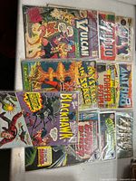 Nine bagged comics laid out on table