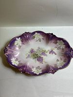 Top view showing floral pattern, purple shading, gilded rim