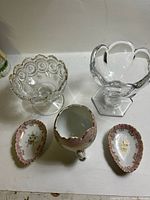 Five items grouped: two pressed glass compotes, porcelain egg cup and two dishes