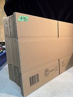 Stack of 17 flat, unassembled new cardboard boxes with barcodes and recycling logos, size 12 1/2 x 9 1/4 x 6 1/2 inches.