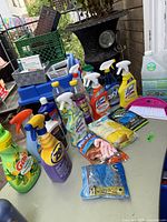 Photo showing a variety of cleaning products and accessories including spray bottles, gloves, a dustpan, and bottles of cleaners.