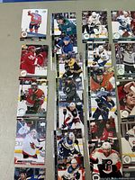 Photo showing a selection of hockey cards displaying various NHL players in different colored uniforms.