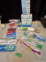 Photo showing the full lot on a surface including toothpaste, toothbrushes, multiple bars of soap, bath crystals, and mouthwash.