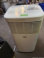 Front view of the white Artic King portable air conditioner showing vents, brand logo, and top control panel with buttons and digital display.