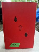 Front cover of the red hardcover book with title and flame icons, showing some wear and a green sticker with #19.