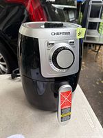 Front view of Chefman air fryer showing dial control and handle with warning sticker