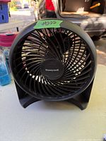 Black Honeywell table fan shown from front angle with visible fan blades and protective grill.