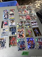 Photo of 27 hockey trading cards arranged on a table showing different players, colors, and teams.