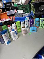 Photo of various shampoo and hand cream bottles arranged on a table, showing brand logos and label text.