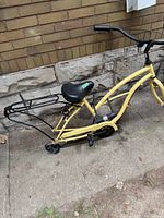 Side view of yellow Sixthirty bike frame showing saddle, rear rack, pedals, and frame detail