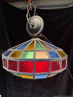 Side angle showing the stained glass colors and metal ceiling mount with chain