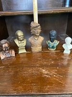 Full view of all five busts on wooden surface showing size and colors