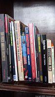 Photo showing 16 books on a shelf related to horror and monster movies. Titles visible include 'Too Much Horror Business,' 'Roger Corman King of the B Movie,' 'FrightFest Guide,' 'King Kong,' and more.