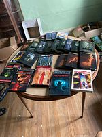 Various horror and thriller DVD box sets arranged on a round wooden table