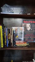 Photo of horror movie books and a poster featuring Phantom of the Opera character