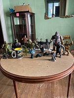 Overview of all monster figurines and collectibles arranged on a brown table with a cup and statues visible.