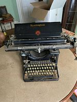 Front view of the black Remington Standard manual typewriter showing the keyboard, typebars, and top cover with logo.