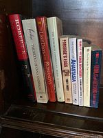 Photo shows all eleven Romanov-related books standing upright on a shelf, titles and spine art visible, colors range from red, white, black and blue.