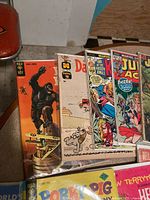 Photo of vintage comic lot showing Gold Key King Kong, Daffy Duck, and several Marvel and Dell comics in sleeves on table.