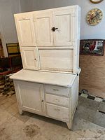 Front view of entire cabinet showing upper cupboards, roll-top center tambour door, lower drawers and door