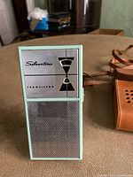 Front view of the Silvertone transistor radio showing light blue body with speaker grille and logo panel.