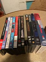 Side view of 13 DVD cases showing titles related to war, remembrance, documentaries, and miscellaneous topics.