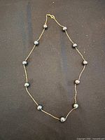 Full view of the black pearl and 14K gold chain necklace