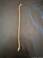 Full view of the tennis bracelet showing length and linkage with amber-colored stones set in sterling silver.