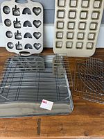 Close-up photo of the two baking pans on top with cooling racks and baking tray below.