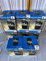 Eight boxed Kichler landscape light fixtures arranged in two rows, showing blue retail packaging and product image.