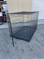 Front and side view of the large folding wire dog crate with door open and plastic tray inside.