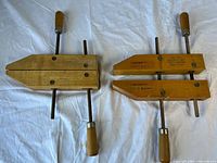 Two handmade Jorgensen wood hand screw clamps on white background, showing entire clamps and handle details.