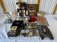 Overview of all Harley-Davidson motorcycle parts and accessories laid on table, mostly new in boxes and some loose like foot pegs and trim panels.