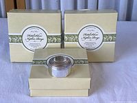 Photo of boxed set of 12 Williams-Sonoma silverplated banded style hotel napkin rings showing original packaging.
