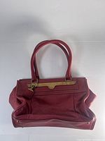 Front and side view of red pebbled leather Chloé shoulder bag on white background