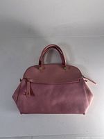 Front view of Furla pink leather dome satchel showing curved top handles, front zippered pocket, and pink leather material.