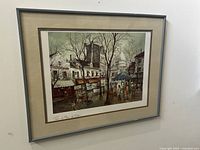 Framed watercolor print showing Paris street scene with buildings, trees and people. Signed by Georges B.