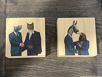 Two small square wood panels with modern folk art paintings of anthropomorphic animals dressed in suits, one rat with cat, one donkey with bird.