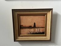 Front view of framed vintage MCM painting on board depicting a lighthouse scene in muted tones with signature visible.