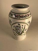 Full side view of the Portmeirion floral vase showing hand-painted purple hyacinth and butterfly design with green leaf border on creamy white ceramic.