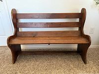 Front view of the solid wood antique bench showing three horizontal slats on backrest and wide plank seat