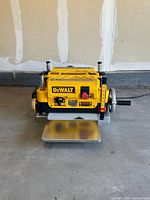 Front view showing DeWalt logo, control switch, infeed table folded down