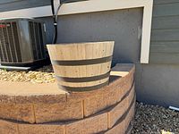 Side view of the wood barrel planter showing tapered shape and metal bands
