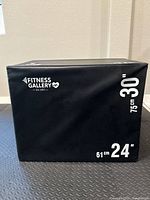 Black plyometric box jump showing 24" and 30" height sides with Fitness Gallery logo, vinyl cover, and large white printed height measurements.