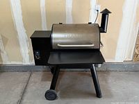 Front‐angle view showing barrel lid, front shelf, pellet hopper and wheels