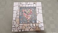 Full view of 12-inch square mosaic artwork featuring a heart motif made from broken patterned crockery pieces.