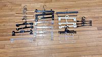 Top view of the 18 assorted hangers on wooden floor showing different materials and clip types.