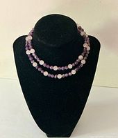 Front view of the necklace displayed on a black velvet bust, showing the alternating bead pattern.