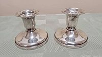 Pair of vintage Birks sterling silver candle holders side by side on a table, showing overall shape and size.